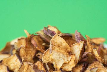 dried apples in white plate on green background