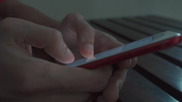 Young man fast typing on smart phone