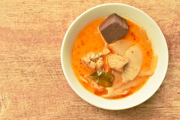 spicy boiled slice pickled bamboo shoot with chicken and blood in coconut milk curry soup on bowl