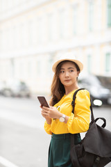 Happy tourist woman used smart phone for searching the street locations