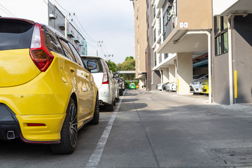 Yellow car parked neatly inside an outdoor parking lot.