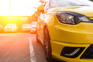 yellow car parked neatly inside an outdoor parking lot.