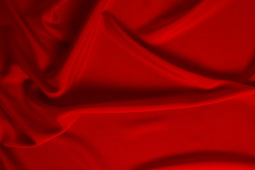 Red silk or satin luxury fabric texture can use as abstract background. Top view.
