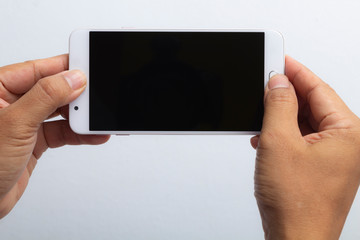 Man hand holding horizontal smartphone with black screen.