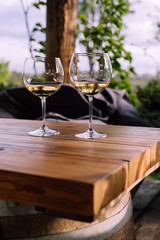 two glasses of white wine on wooden table, blurred background