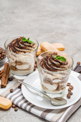 Classic tiramisu dessert in a glass on concrete background