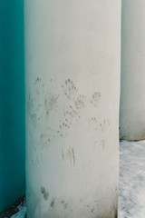 Traces of dirty hands in a white column near a residential building in the city