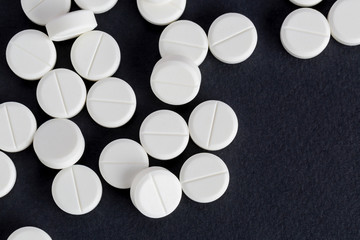 Medicinal round tablets on a black background