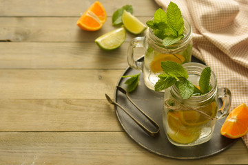 Homemade lemonade with lime, mint in a mason jar on a wooden rustic table. Summer drinks. Copy space.