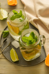 Homemade lemonade with lime, mint in a mason jar on a wooden rustic table. Summer drinks.