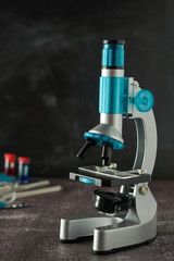 Education, science and children concept. Microscope isolated on black background. Studying biology at school laboratory.