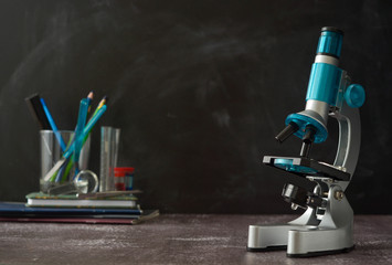 Education, science and children concept. Microscope isolated on black background. Studying biology at school laboratory.