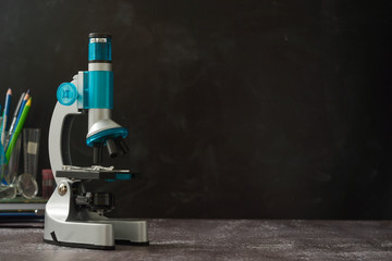 Back to school. Microscope isolated on black background. Studying biology at school laboratory.