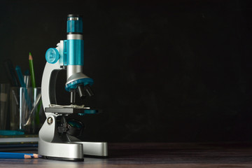 Education, science and children concept. Microscope isolated on black background. Studying biology at school laboratory.