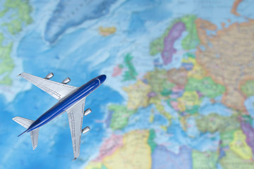 Fototapeta na wymiar Toy plane over world map. Airplane flying to the Europe. Air trip, travel by plane, booking tickets, flight by aircraft concept