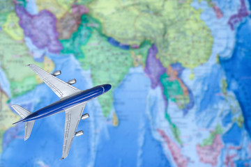 Fototapeta na wymiar Toy plane over world map. Air trip to Asia. travel by plane, booking tickets, flight by aircraft concept