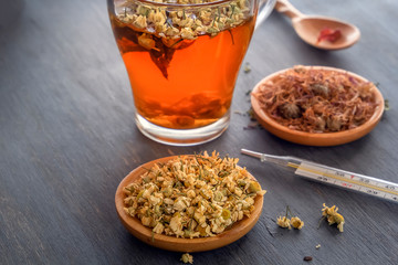 Herbal tea with pharmaceutical chamomile on a gray wooden table. Close-up