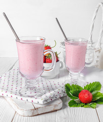 Glass of fresh strawberry and yogurt smoothie on white wooden table