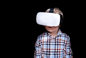 Little blond boy with glasses of virtual reality. Plaid shirt. Black background