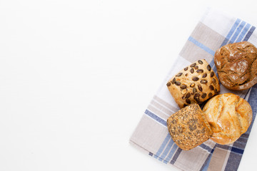 Gold rustic crusty loaves of bread and buns on wooden background. Still life captured from above top view, flat lay.