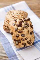 Gold rustic crusty loaves of bread and buns on wooden background. Still life captured from above top view, flat lay.