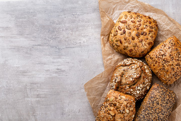 Assortment of baked bread on wooden table background.