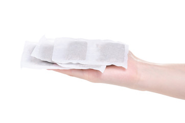 herbal tea bags in hand on white background isolation
