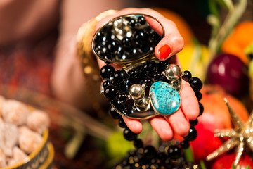 Cropped Hand holding Mirror with Jewellery