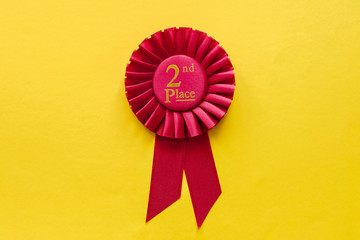 2nd Place red winners ribbon rosette on yellow