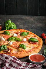 Traditional Italian pizza on a dark background copy space. 