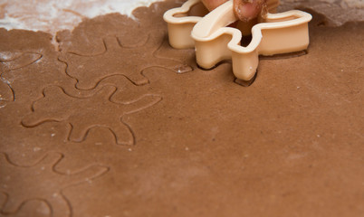 cutting out  a gingerbread with human hand