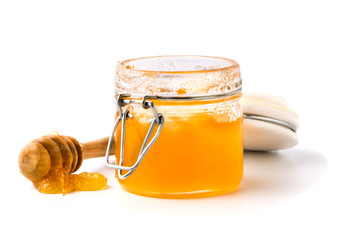 honey dipper and honey in jar on white background