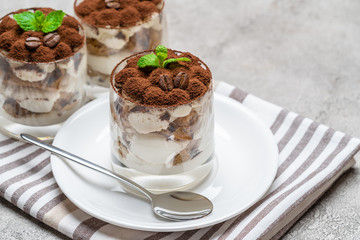 Classic tiramisu dessert in a glass on concrete background