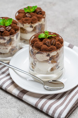 Classic tiramisu dessert in a glass on concrete background