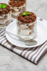 Classic tiramisu dessert in a glass on concrete background