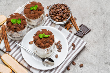 Classic tiramisu dessert in a glass on concrete background