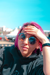young woman with pink hair in sunglasses