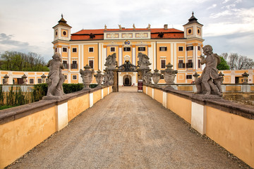 Fototapeta na wymiar Entrance to the old castle with two rows of sculptures, historic background