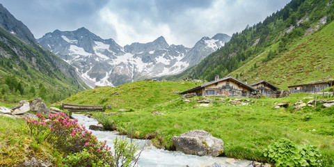 Fototapeta na wymiar Panorama von Almhütten mit Gletscher im Hintergrund