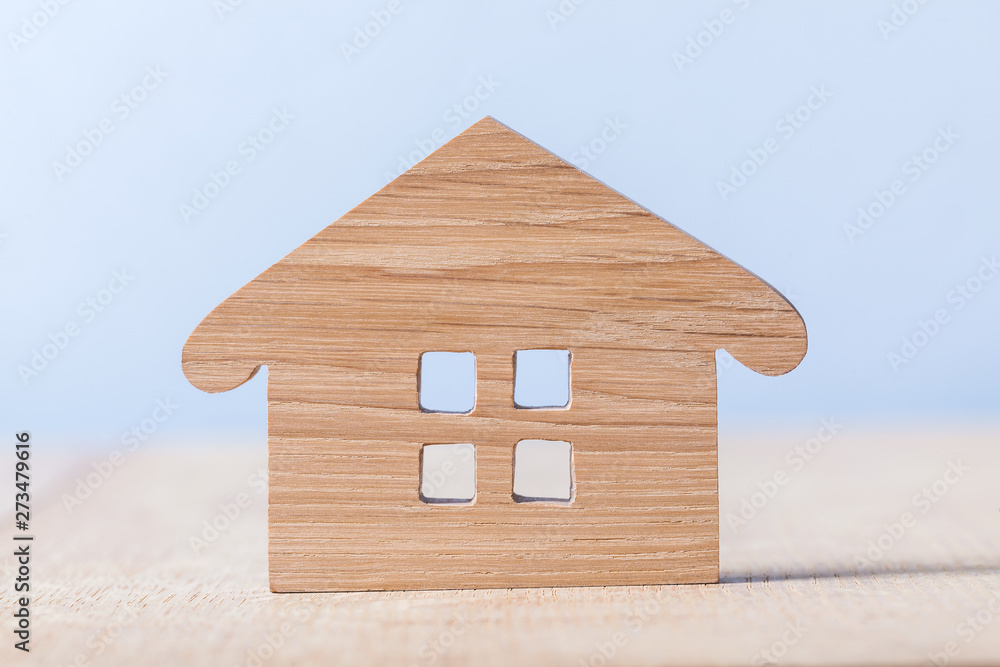 Wall mural symbol of wooden house on blue and wooden background