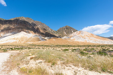the panorama view at the  white-yellow hills volcano with white and yellow sulfur crystals near the Stefanos crater on the island of Nisyros in Greece