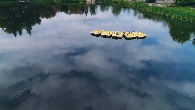 Aerial view of moving slowly paddleboats on the calm lake. 4K.