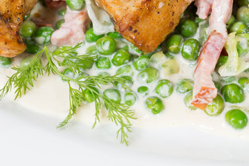 Grilled chicken fillets with bacon and peas.