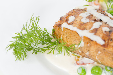 Grilled chicken fillets with bacon and peas.