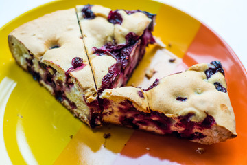 tasty food three piece of cake with berries on the bright yellow-orange plate 