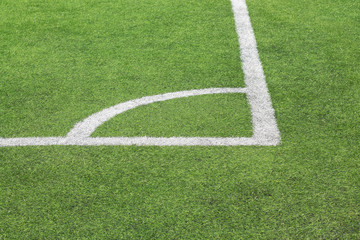 Obraz premium Marking white paint of a corner on a green lawn of the football field.