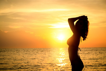 Girls wearing bikinis playing in the sea in the evening. silhouette