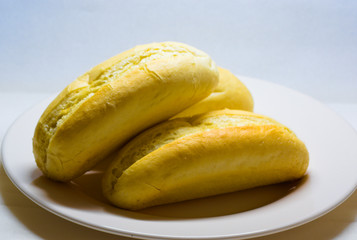 buns of white bread on on white plate with faded background