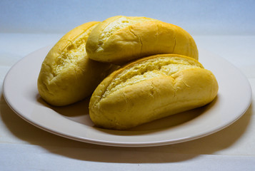 buns of white bread on on white plate with faded background