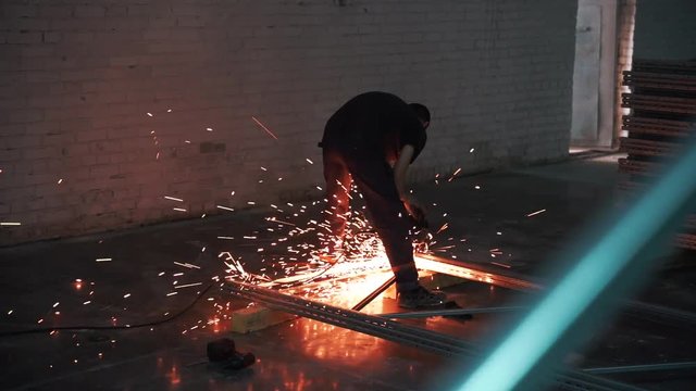 Man works circular saw in slow motion. Flies of spark from hot metal. The man's hard work. Man Chlef and smooth surface. Man worked over the steel. close-up of hand and electric saws metal. Close-up